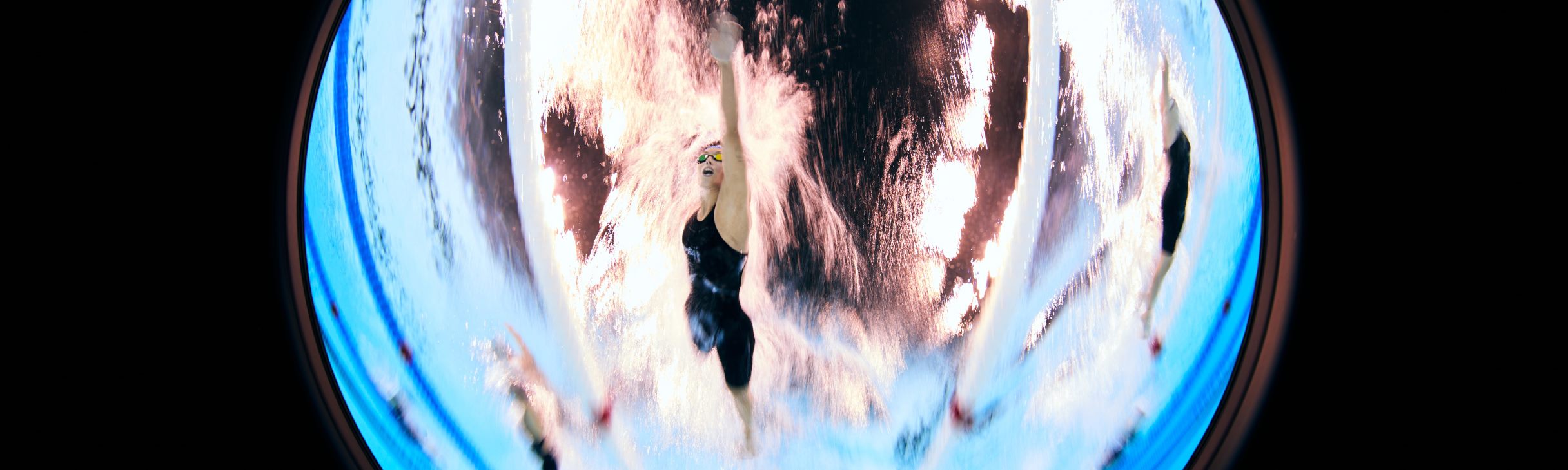 An underwater photo of three female Para swimmers